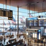 Imagine a high-resolution, realistic image illustrating a bustling scene at a major U.S. airport. The gate area is filled with eager passengers waiting to board their flight. Prominent signage shows the logo of a new low-cost airline, proudly announcing 'Now Serving New Routes'. There are digital display boards that show a list expanding destinations. Some airport personnel are quietly engaged in their tasks, ensuring everything runs smoothly. Planes branded with the airline's logo can be spotted on the tarmac through the large glass windows. Their fuselages gleam under the sunlight, symbolizing the rise of a novel budget-conscious air-travel option.